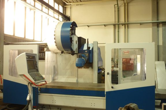 Moderne CNC-Maschine in einer hellen Fertigungshalle.
