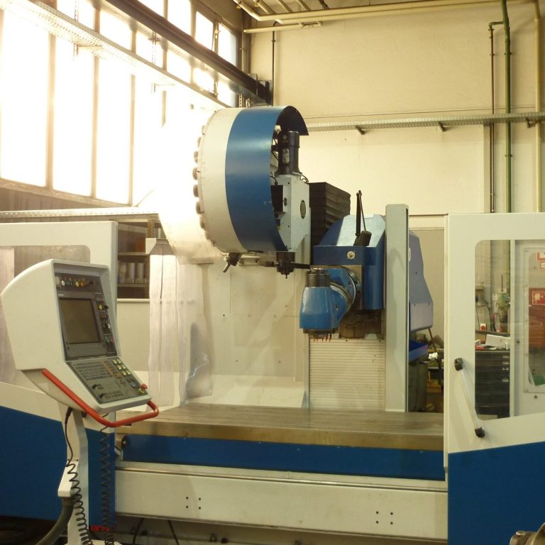 Tischbohrwerk mit Steuerungseinheit in einer hellen Fertigungshalle.