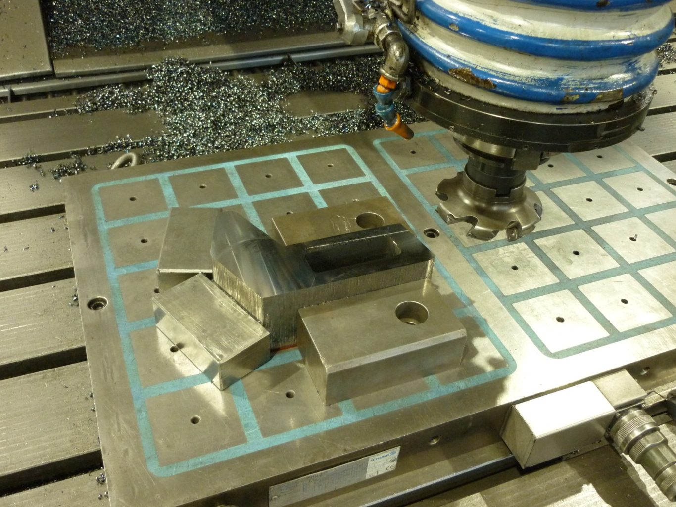 Fräsbearbeitung auf Magnetspannplatte Präzise Metallbearbeitungsmaschine mit bearbeitetem Werkstück und Spänen.