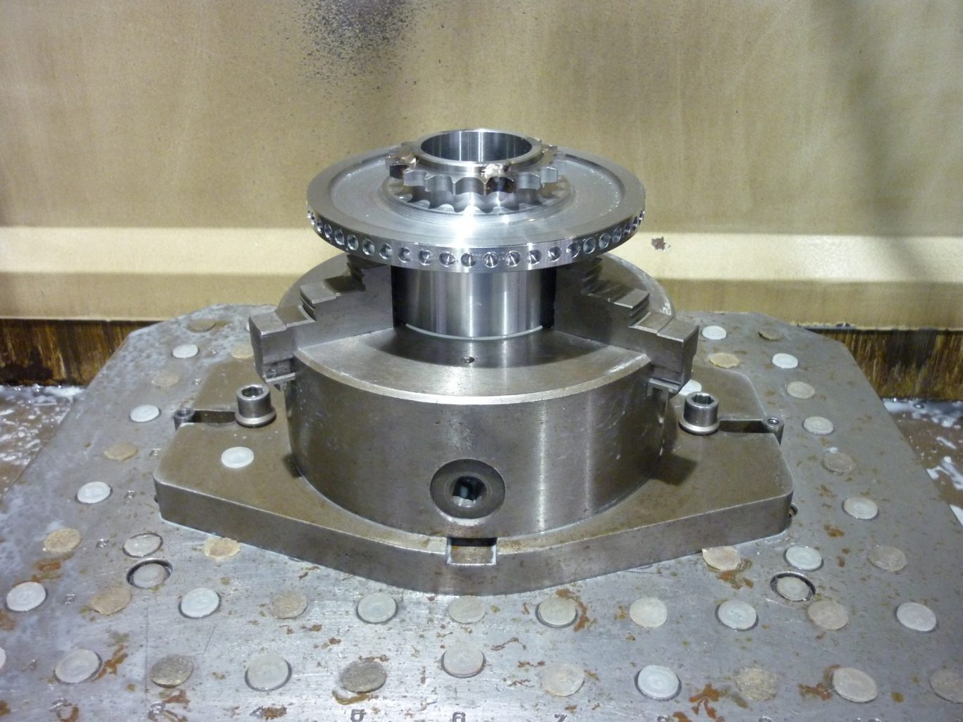 CNC-Drehteil mit umlaufendem Bohrbild Metallisches Bauteil mit präzisen Einkerbungen auf einer Werkbank.