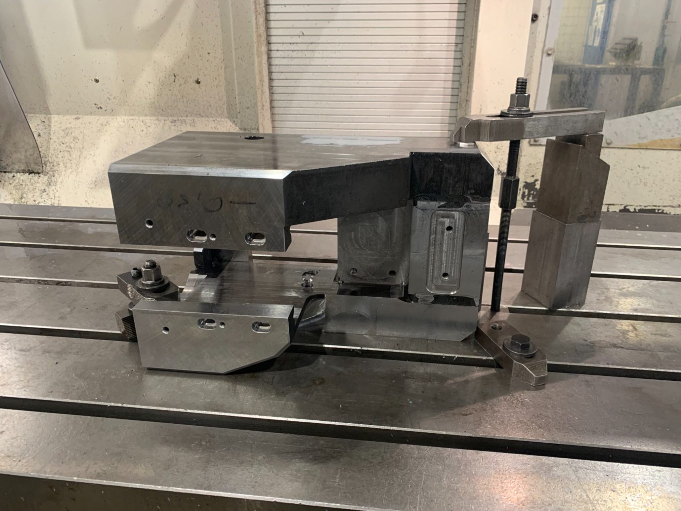 CNC-Zerspanung eines Schweißbau-Werkstück Maschine zur Bearbeitung mit metallischem Gehäuse und präzisen Vorrichtungen.